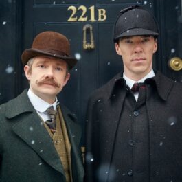 Sherlock Holmes și Doctor Watson sunt în fața celebrei uși, 221B. Sherlock poartă o haină neagră și o pălărie neagră, iar Watson are o haină verde închis și pălărie maro. Sherlock este unul dintre cele mai bune seriale polițiste la ora actuală.