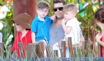 Gemenii lui Ricky Martin sunt în brațe la tatăl lor celebru. Unul poartă ochelari și un tricou albastru, iar celălalt un tricou alb. Ambii se uită la animalele de la zoo