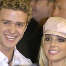 Britney Spears și Justin Timberlake zâmbesc pe covorul roșu. Ea poartă o sapcă de culoare bej și lansase deja albumul care a devenit unul dintre cele mai importante 12 albume din secolul 21