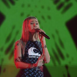Alina Eremia, pe scenă, în timpul unui concert, cu microfonul în mână