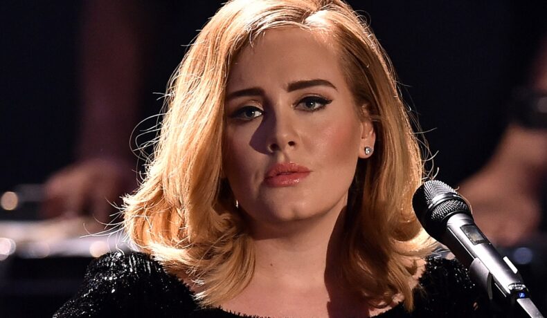 Adele machiata si aranjata, cu parul pe spate, îmbrăcată în negru