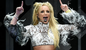 Britney Spears a dezvăluit de ce face poze nud. Aici este la un concert și are un top scurt și o fustă neagră mini