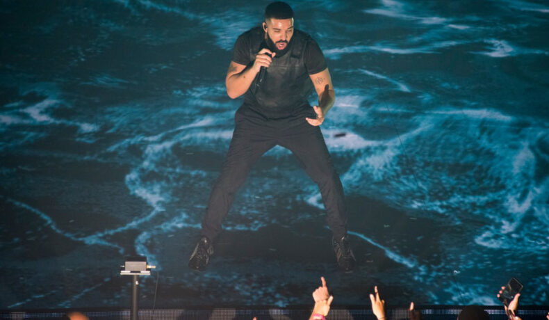Drake i-a dat unui fan 50.000 de dolari. Fanii au aplaudat cu mult entuziasm decizia rapperului. El este pe scenă în fața publicului într-un pantalon negru și un tricou asortat, negru. Cântă și ține microfonul cu mâna dreaptă