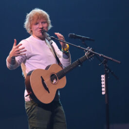Ed Sheeran, pe scenă, cu chitara și cu microfonul alături