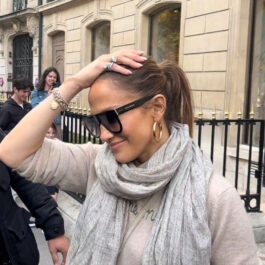 Jennifer Lopez s-a simțit nesigură. Ea își duce mâna la cap pentru a masca asta. Poartă un pulover bej și o eșarfă mare, de aceeași culoare