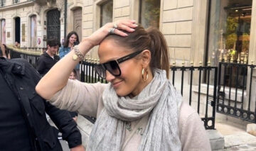Jennifer Lopez s-a simțit nesigură. Ea își duce mâna la cap pentru a masca asta. Poartă un pulover bej și o eșarfă mare, de aceeași culoare