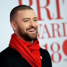 Justin Timberlake în timp ce zâmbește și poartă un fular roșu