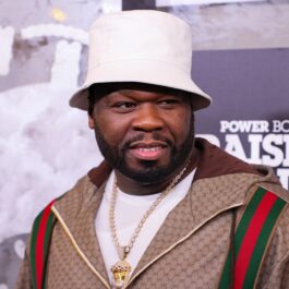 50 Cent îmbrăcat într-o jachetă Gucci și cu o bască albă în cap