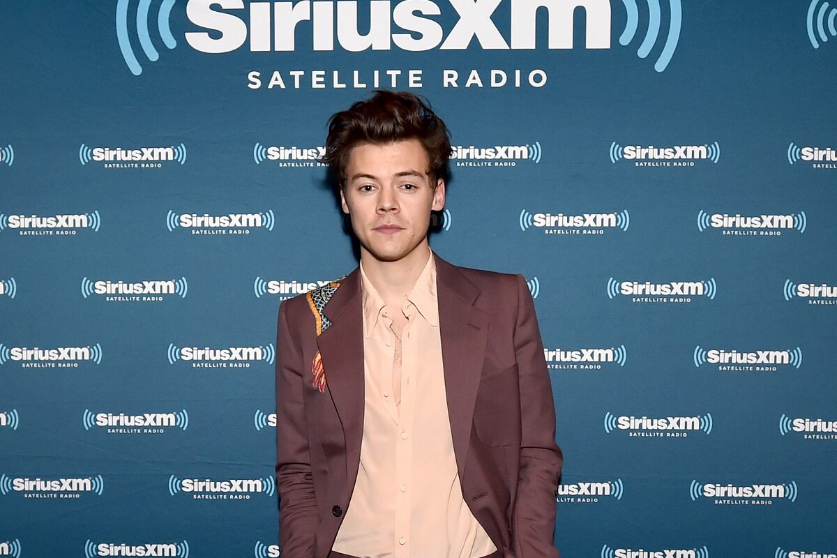Harry Styles îmbrăcat cu un costum maro