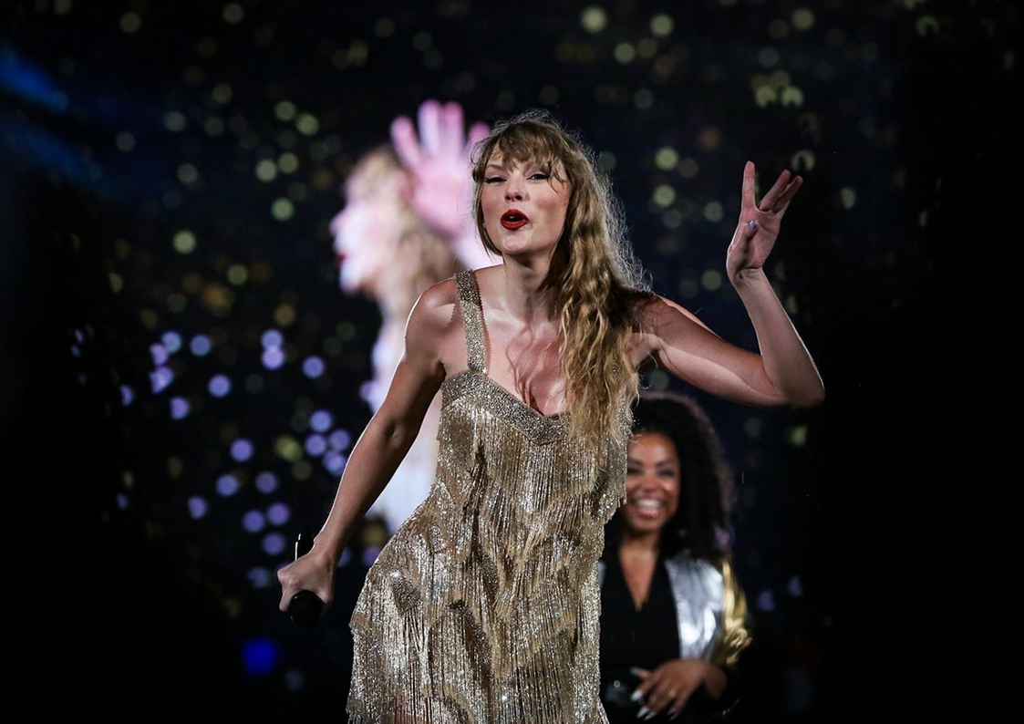 Câștigătorii Billboard Music Awards 2023. Taylor Swift este pe scenă și poartă o rochie aurie cu franjuri