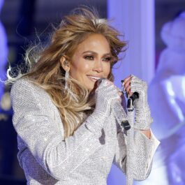 Jennifer Lopez într-o ținută strălucitoare cântând la microfon