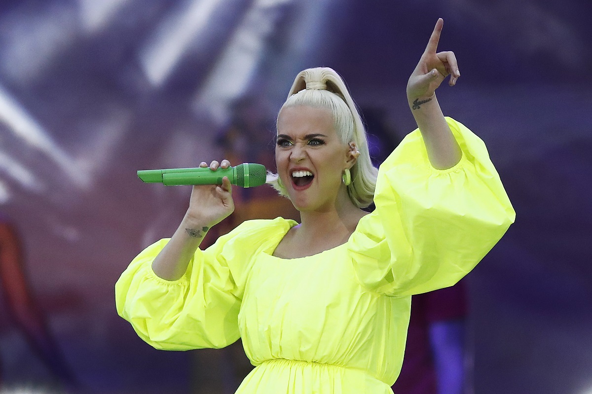 Katy Perry îmbrăcată într-o rochie de culoare galben neon în timp ce cântă