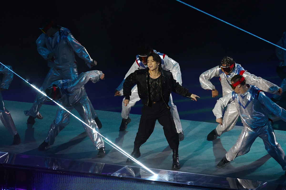 Jungkook îmbrăcat în negru dansând alături de echipa lui în timpul unui concert