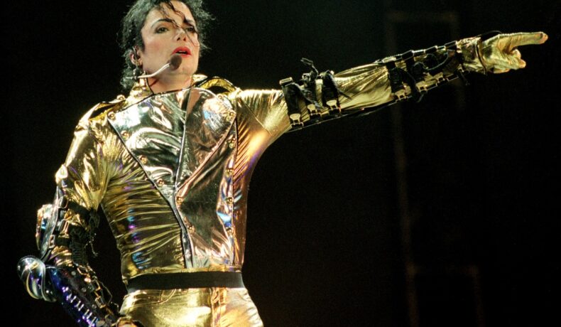 Michael Jackson într-o costumație aurie și stălucitoare în timp ce cântă