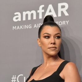 Kourtney Kardashian îmbrăcată cu un maiou negru și părul prin în coc