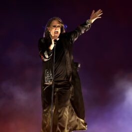 Ozzy Osbourne îmbrăcat în negru în timp ce cântă pe scenă