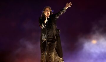 Ozzy Osbourne îmbrăcat în negru în timp ce cântă pe scenă