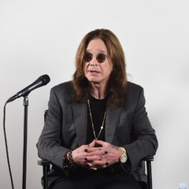 Ozzy Osbourne îmbrăcat în negru în timp ce vorbește în fața unui microfon