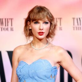 Taylor Swift îmrăcată cu o rochie albastră purtând un colier cu perle