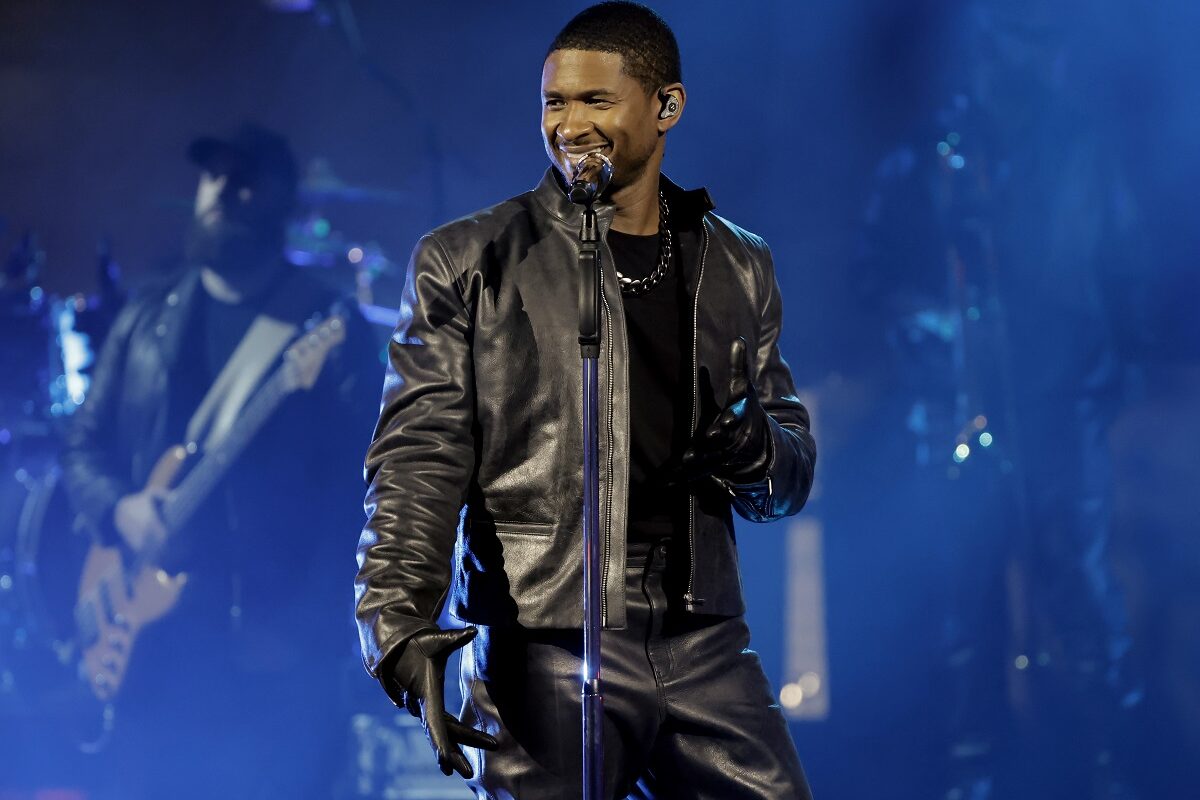 Usher îmbrăcat în negru în timp ce se afla pe scenă în fața unui microfon