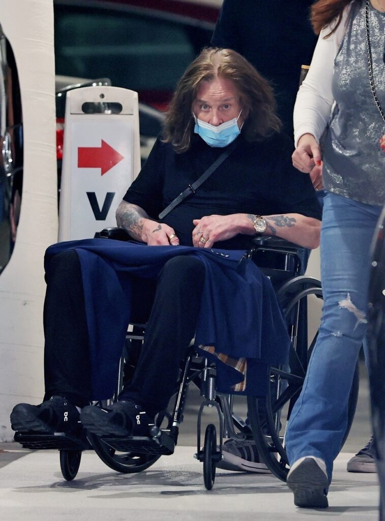 Ozzy Osbourne, cu mască pe față, în scaun cu rotile
