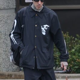 Travis Barker, în haine închise la culoare, cu căciulă în cap, pe stradă