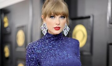 Taylor Swift îmbrăcată într-o rochie albastră cu guler purtand cercei strălucitori