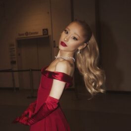 Ariana Grande îmbrăcată într-o rochie cu umeri goi de culoare roșie