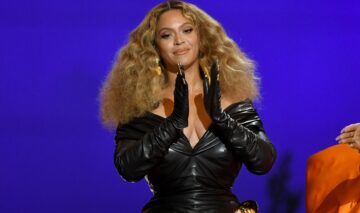 Beyonce îmbrăcată într-o rochie neagră mulată în timp ce aplaudă