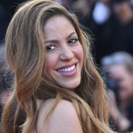 Shakira uitându-se în drepta ei și zâmbind