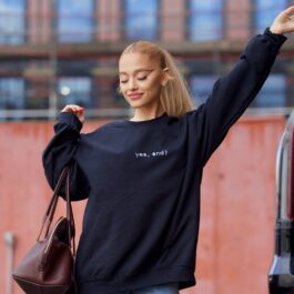 Ariana Grande îmbrăcată cu o bluză neagră pe care este scris numele noului ei cântec