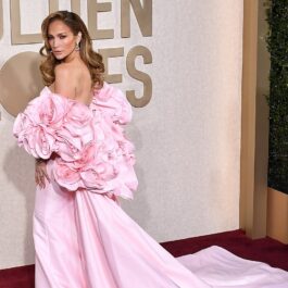 Jennifer Lopez îmbrăcată într-o rochie lungă roz cu ornamente în formă de trandafiri