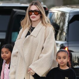 Khloé Kardashian îmbrăcată într-un palton crem în timp ce le ține de mână pe True și Dream / Profimedia Images