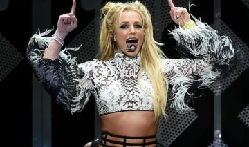Britney Spears îmbrăcată într-un top argintiu în timp ce cântă și dansează