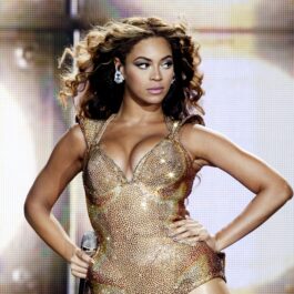 Beyonce îmbrăcată într-o rochie sexy aurie decoltată și fără mâneci