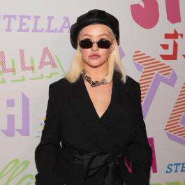 Christina Aguilera îmbrăcată într-o ținută neagră cu ochelari de soare și bonetă de aceeași culoare