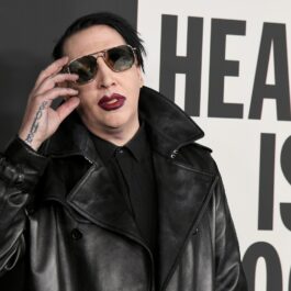 Marilyn Manson îmbrăcat într-o cămașă neagră și o geacă din piele de aceeași culoare