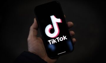 Un telefon pe care apre logoul aplicației TikTok