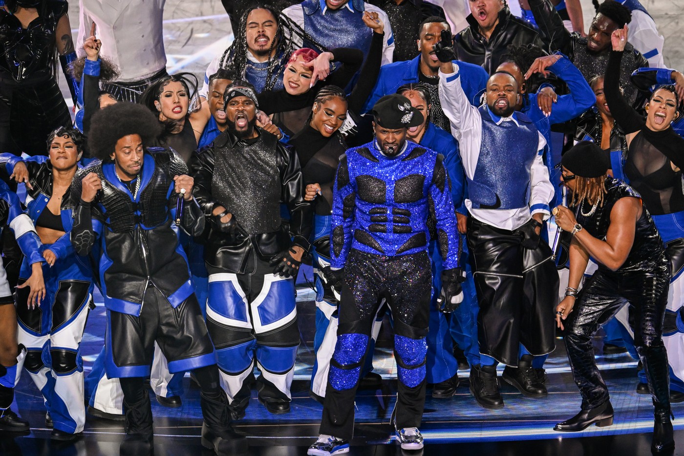 Usher a făcut un spectacol de senzație la Super Bowl 2024. Aici poartă un costum alb albastru cu negru