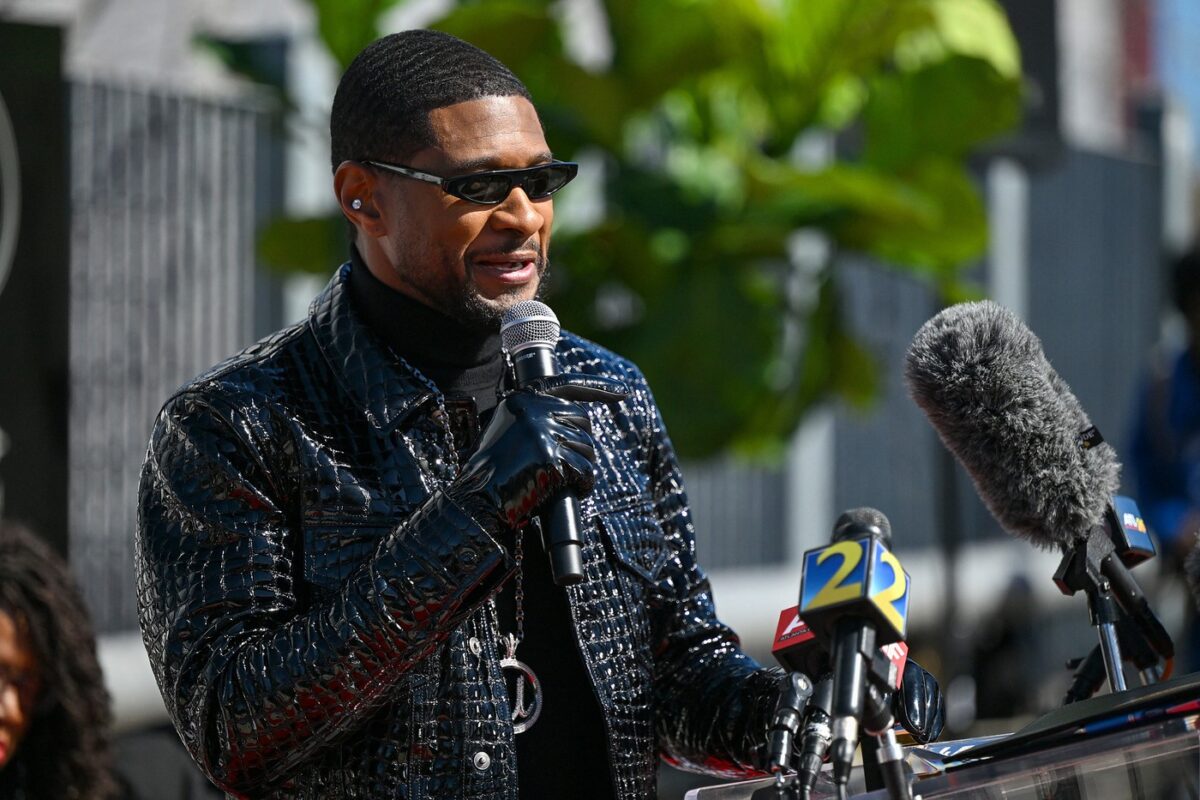 Usher, cu ochelari de soare și o geacă din piele cu ținte