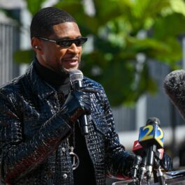 Usher, cu ochelari de soare și o geacă din piele cu ținte