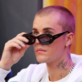Justin Bieber îmbrăcat într-un hanorac alb, cu ochelari de soare negri