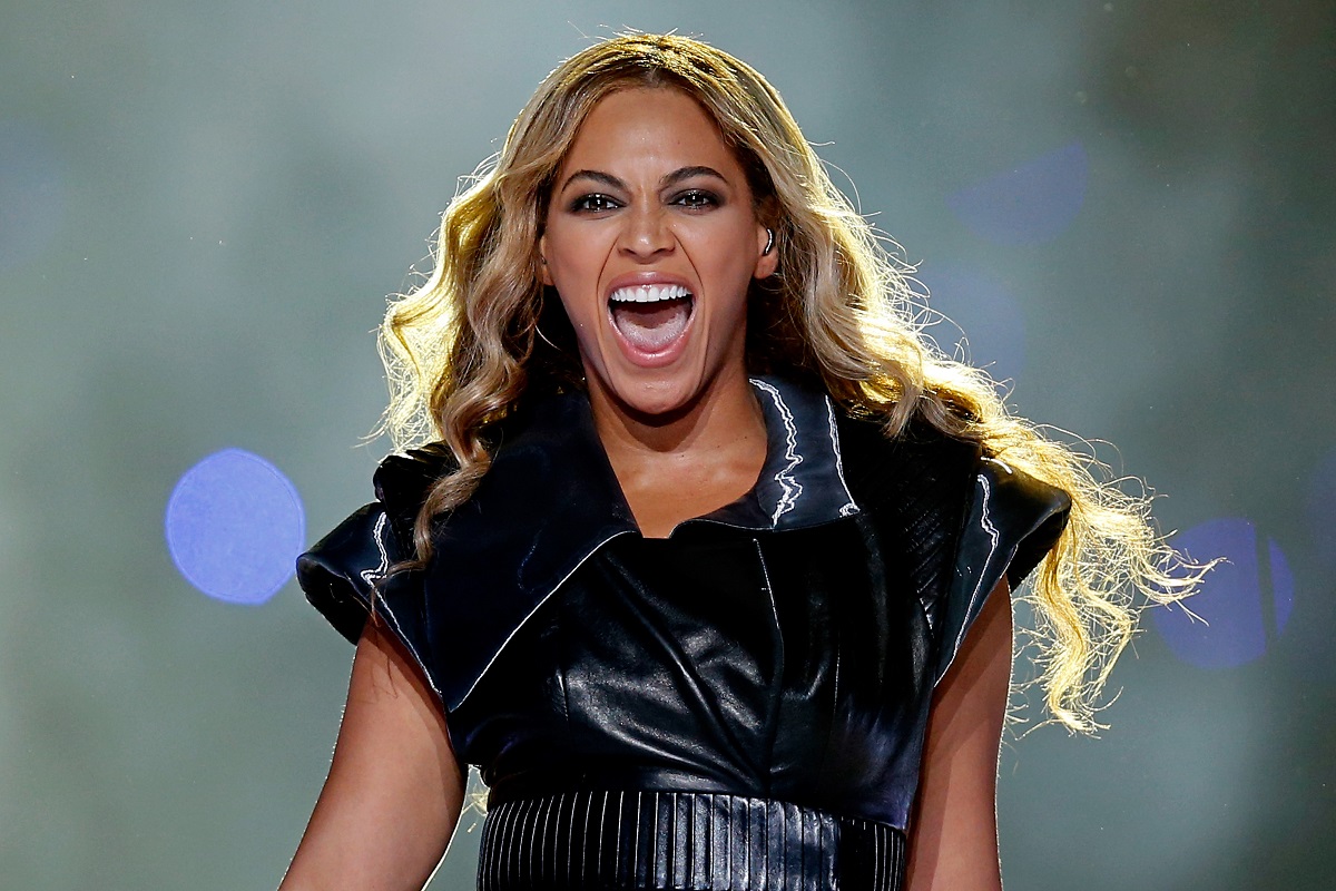 Beyoncé îmbrăcată într-o ținută neagră strălucitoare din latex în timp ce cântă