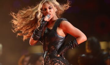 Beyonce îmbrăcată într-o ținută sexy complet neagră în timp ce cântă la microfon