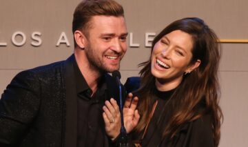 Justin Timberlake și Jessica Biel îmbrăcați în ținute negre în timp ce râd și vorbesc la microfon