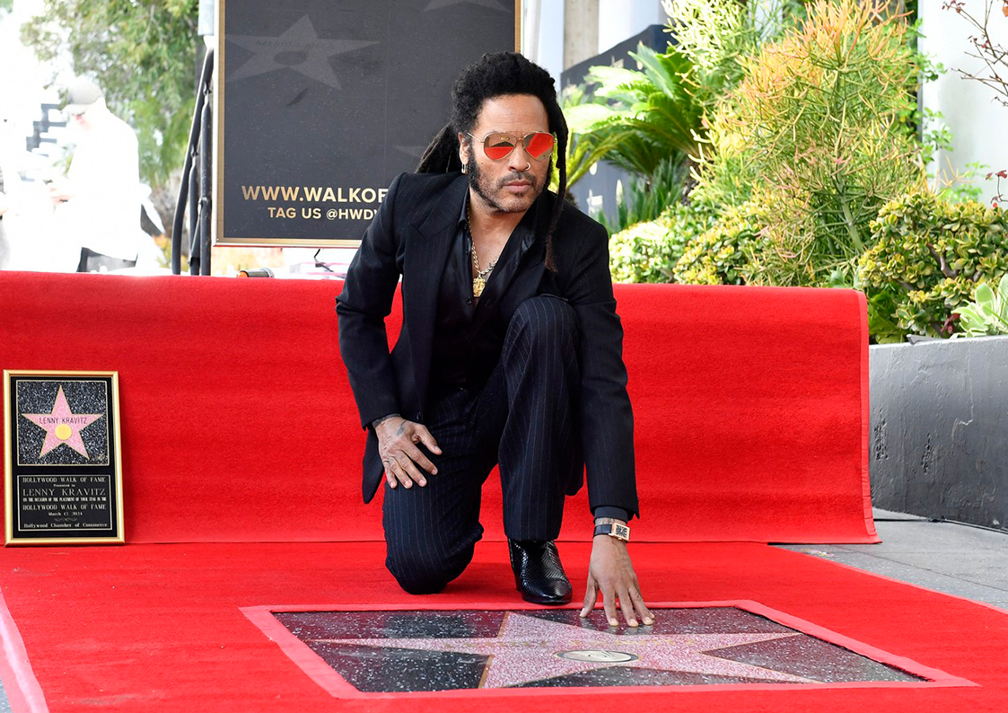 Lenny Kravitz are o stea pe Hollywood Walk of Fame. Aici este în genunchi, cu mâna stângă pe stea