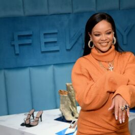 Rihanna îmbrăcată într-o rochie tip pulover de culoare portocalie cu guler
