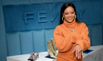 Rihanna îmbrăcată într-o rochie tip pulover de culoare portocalie cu guler
