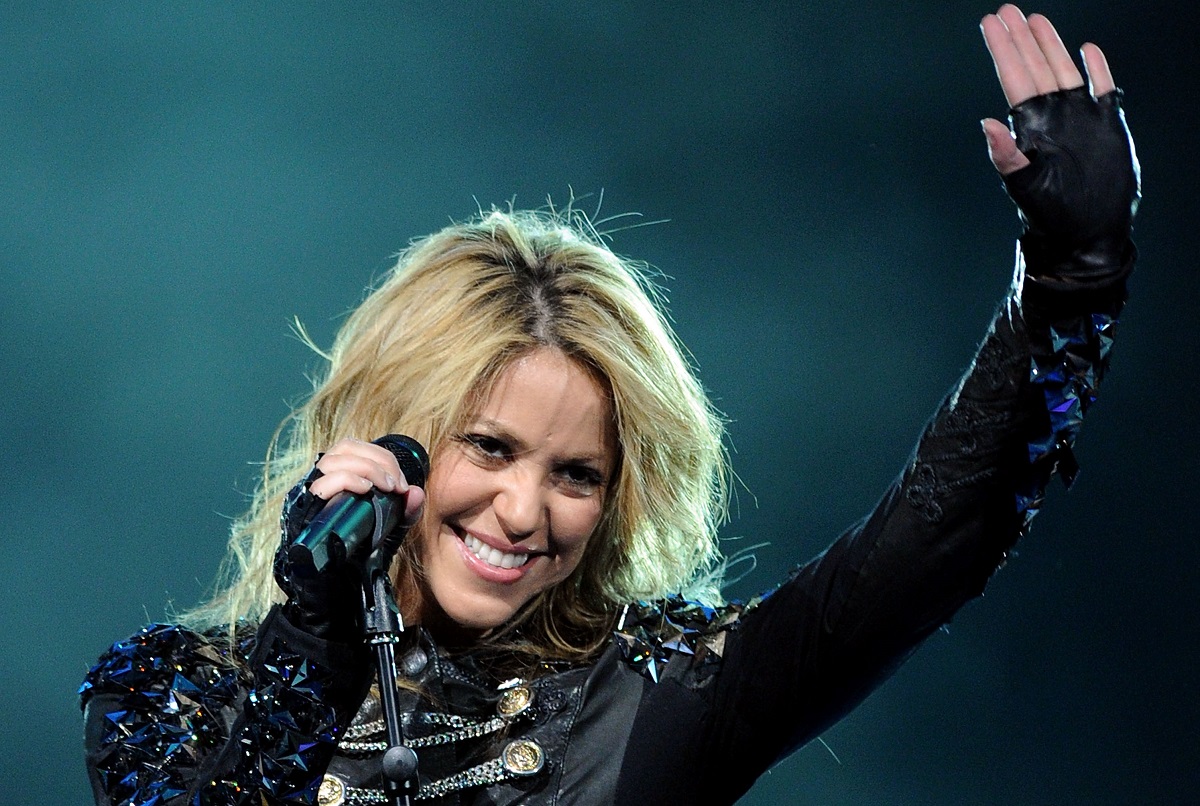 Shakira îmbrăcată într-o ținută neagră strălucitoare în timp ce își salută fanii