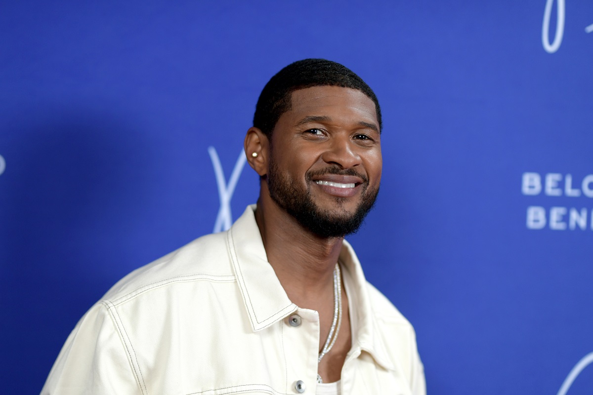 Usher îmbrăcat cu o jachetă albă și purtând un lănțișor la gât